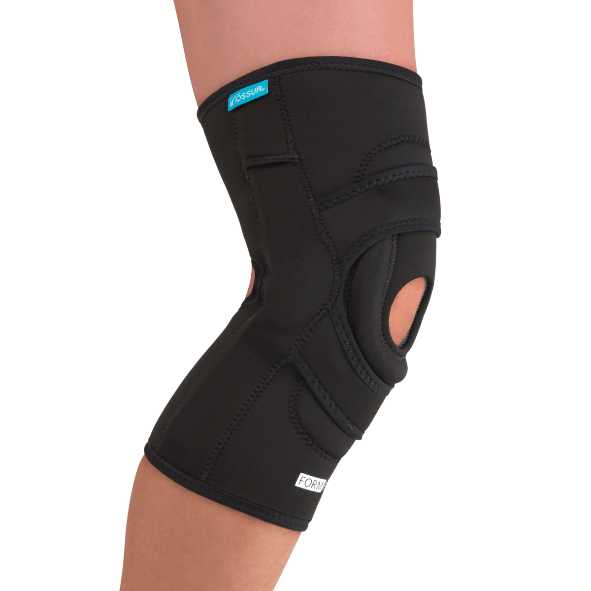 Knee brace with open patella cutout and lateral J buttress worn on leg, black neoprene with stitched panels