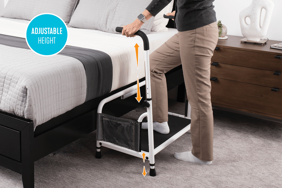 Bed step stool with adjustable-height grab bar and mesh storage pocket, shown in use beside a bed
