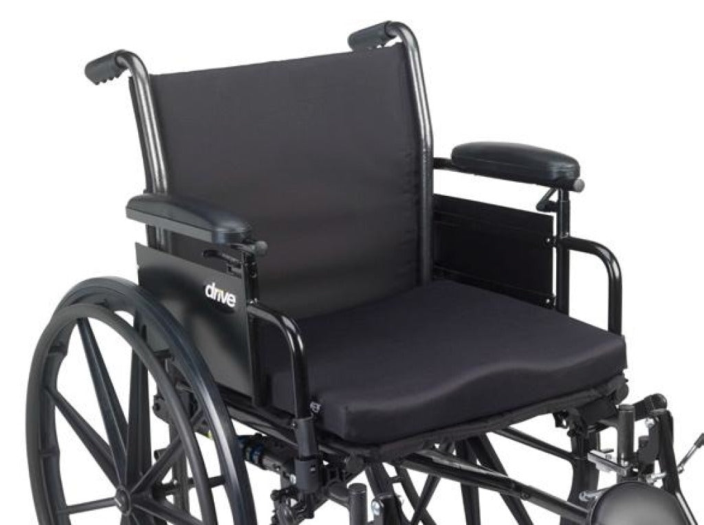 Wheelchair seat cushion in black fabric, contoured foam design, shown placed on a manual wheelchair seat