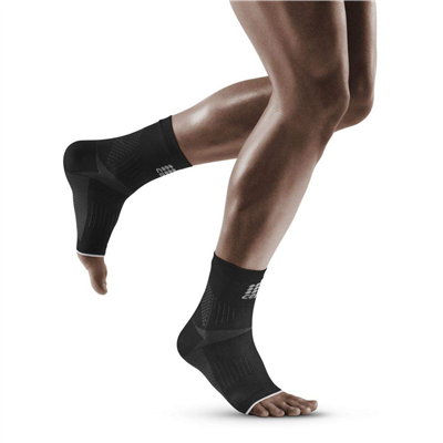 Plantar fasciitis sleeves in black worn on both ankles of a person mid-stride, open-toe design with textured knit panels