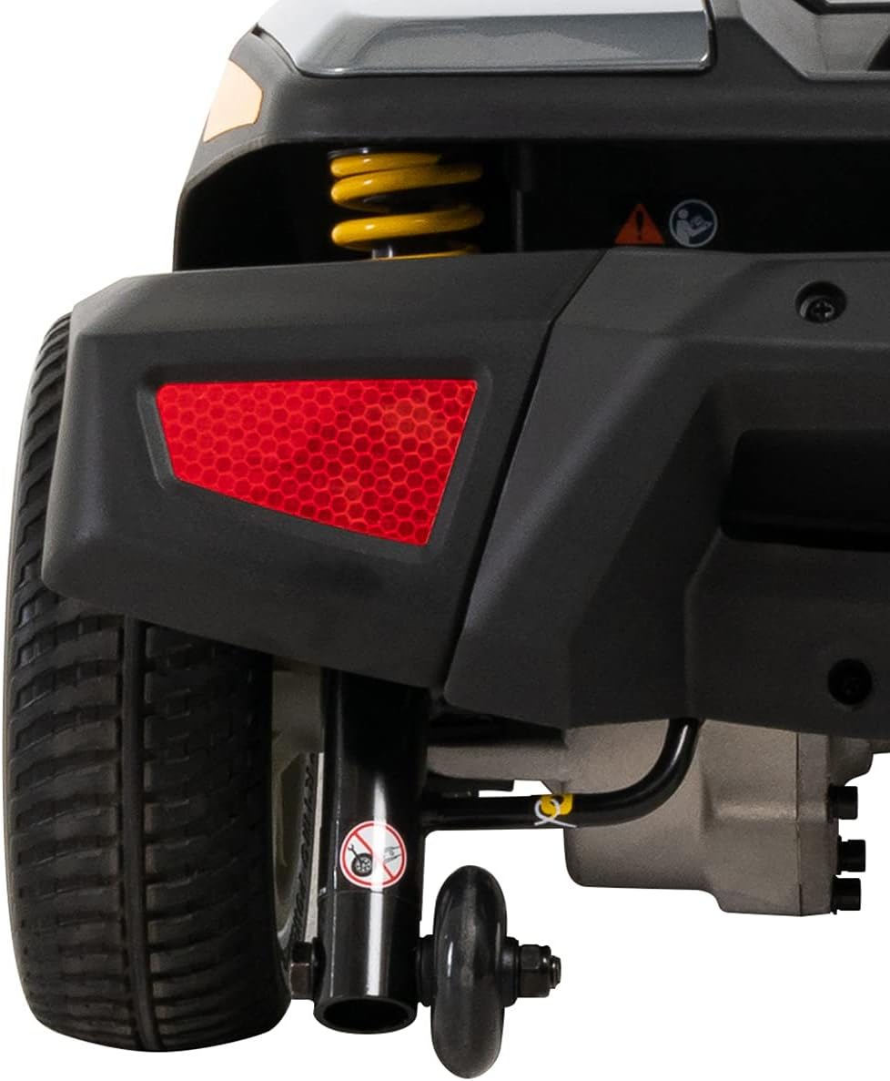 Power scooter rear end showing red reflector, yellow suspension spring, rear wheels, and anti-tip wheel assembly