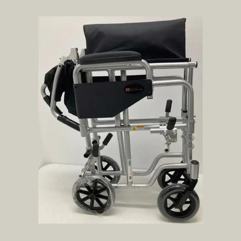 Transport wheelchair with silver aluminum frame, black padded seat and back, small rear wheels, and hand brakes, shown from