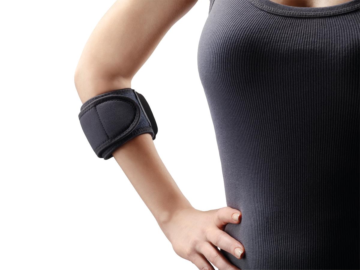 Elbow strap with padded pressure pad worn just below the elbow on a person's right arm, shown against white background