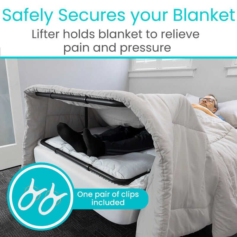 Blanket lifter with black metal frame raising a gray comforter off a person's legs while they rest in bed