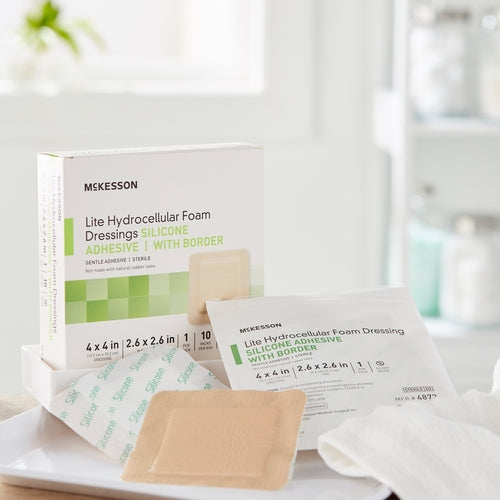 McKesson Lite Hydrocellular silicone adhesive foam dressings with box and individual sterile packets on white surface