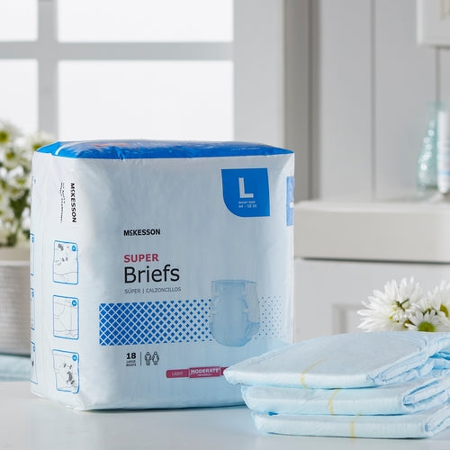 McKesson Super Briefs adult incontinence brief package in size large with folded briefs stacked beside it on a countertop