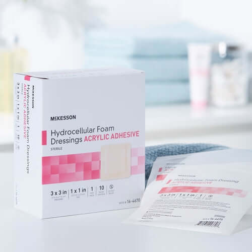 Hydrocellular foam dressing box with acrylic adhesive border and individual sterile packet on white surface