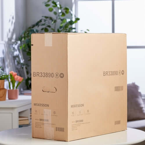 McKesson incontinence brief packaging in a sealed corrugated cardboard shipping box on a white table
