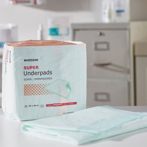 McKesson Super Underpads package of 10, 30x36 inch, with a single unfolded pad displayed in front on a countertop