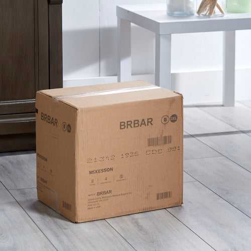 Incontinence brief cardboard shipping box labeled BRBAR by McKesson, sitting on a light wood floor