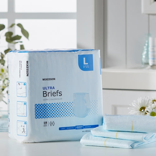 McKesson Ultra Briefs incontinence brief package in Large size, 18 count, displayed on white surface with flowers nearby
