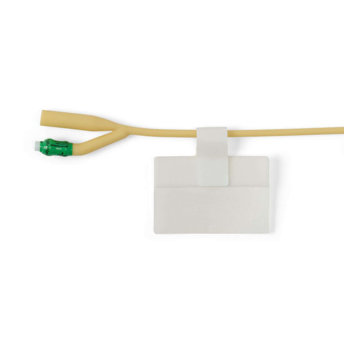 Catheter securement adhesive patch with hook-and-loop strap holding a latex Foley catheter with green valve connector on