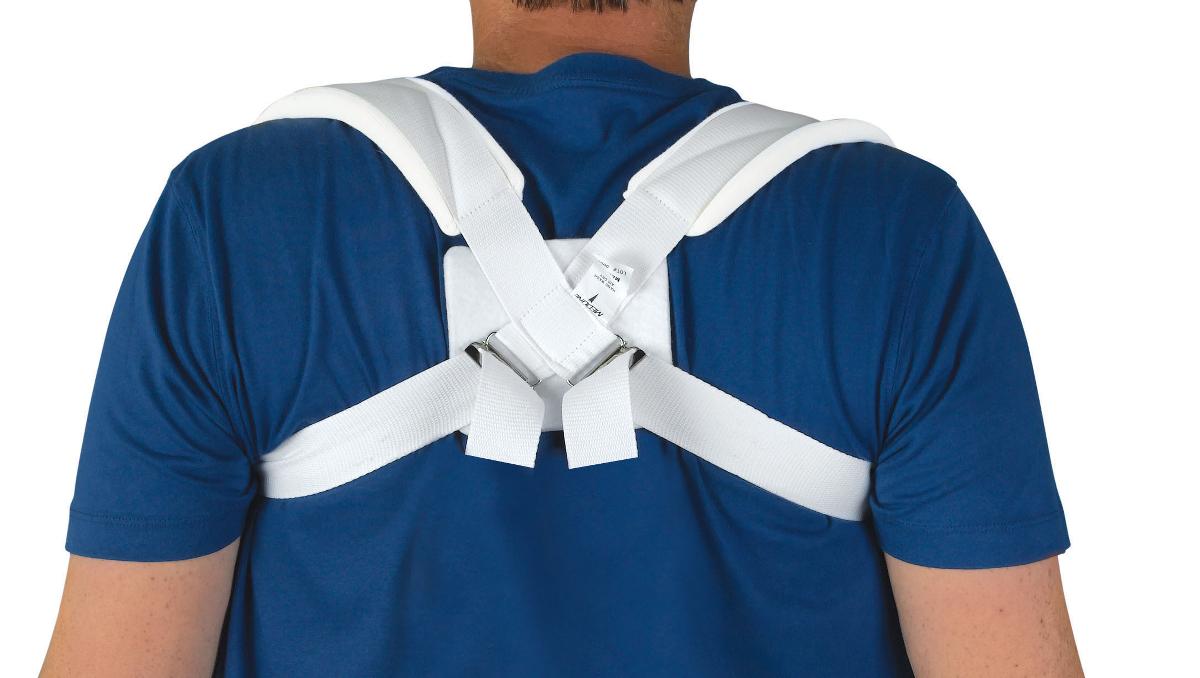 Clavicle strap in white with figure-eight design and metal buckle closure, shown worn on a person's back over a blue shirt