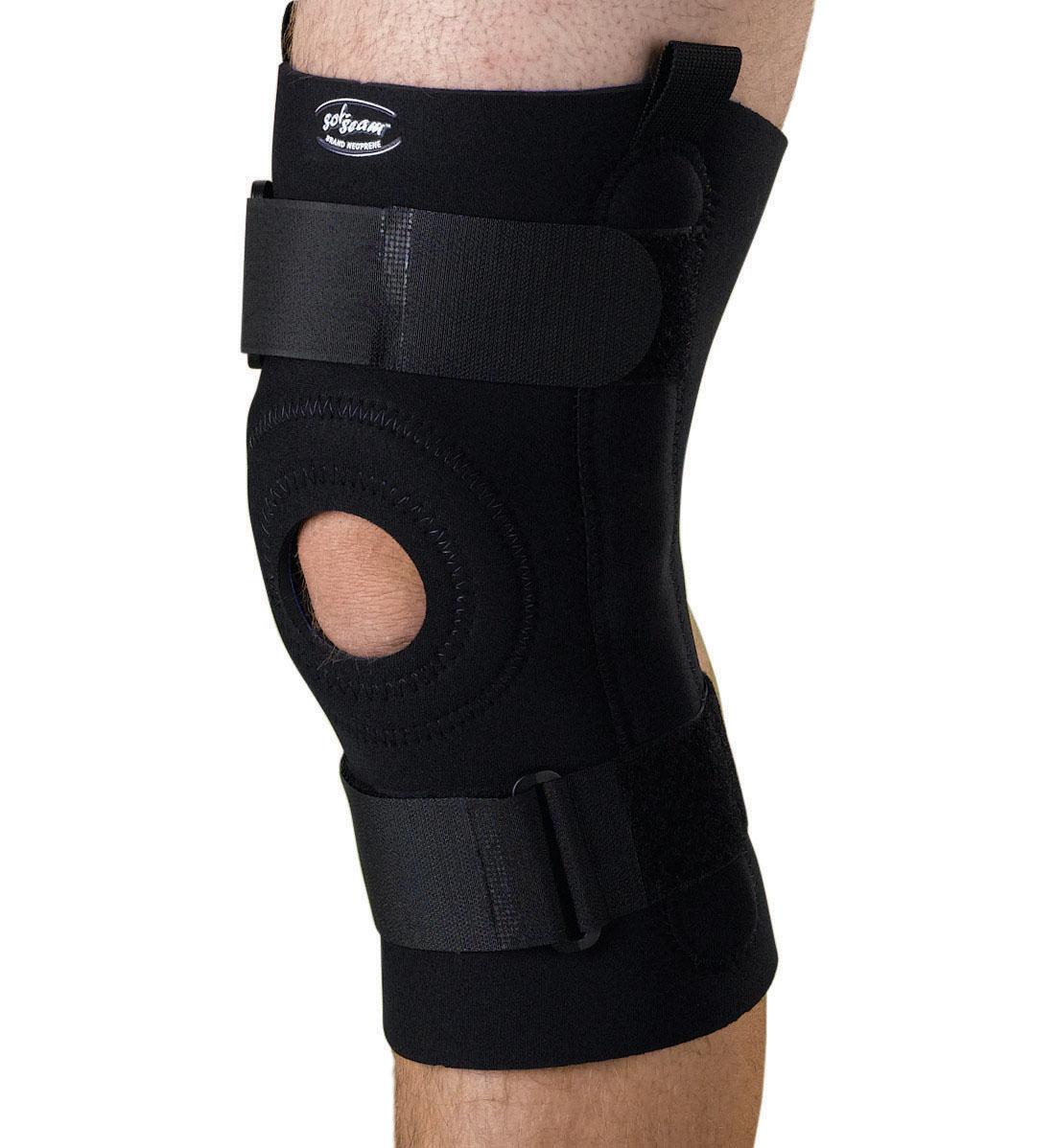 Hinged knee support in black neoprene with open patella cutout, side hinges, and adjustable hook-and-loop straps, worn on leg