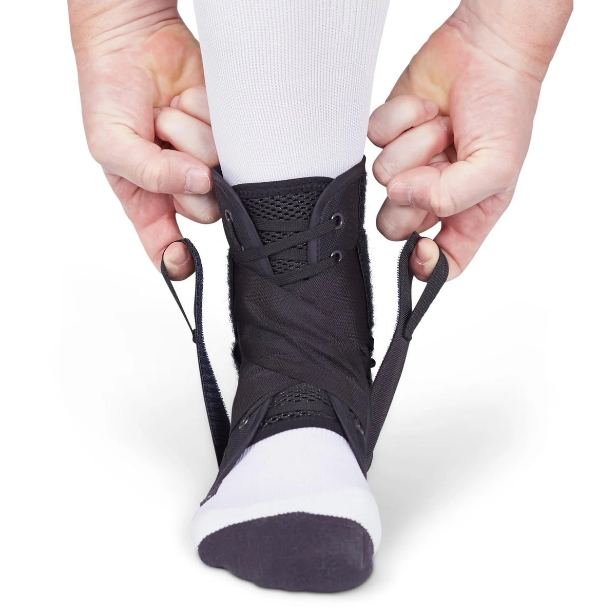 Ankle brace with lace-up closure being fastened over a white sock, shown from the front on a bare white background