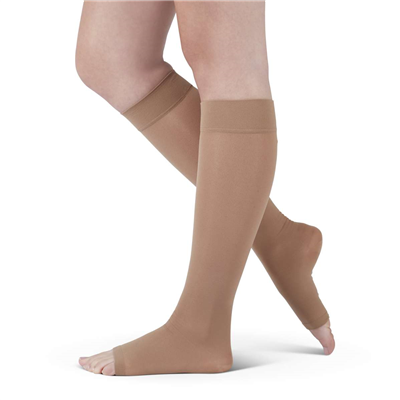 Compression stocking in beige, knee-high open-toe style worn on a person's lower leg, shown from side angle