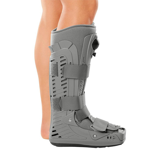 CAT Walker Boot shown on lower leg, gray rigid shell with side panels, hook-and-loop straps, and non-skid sole, side view