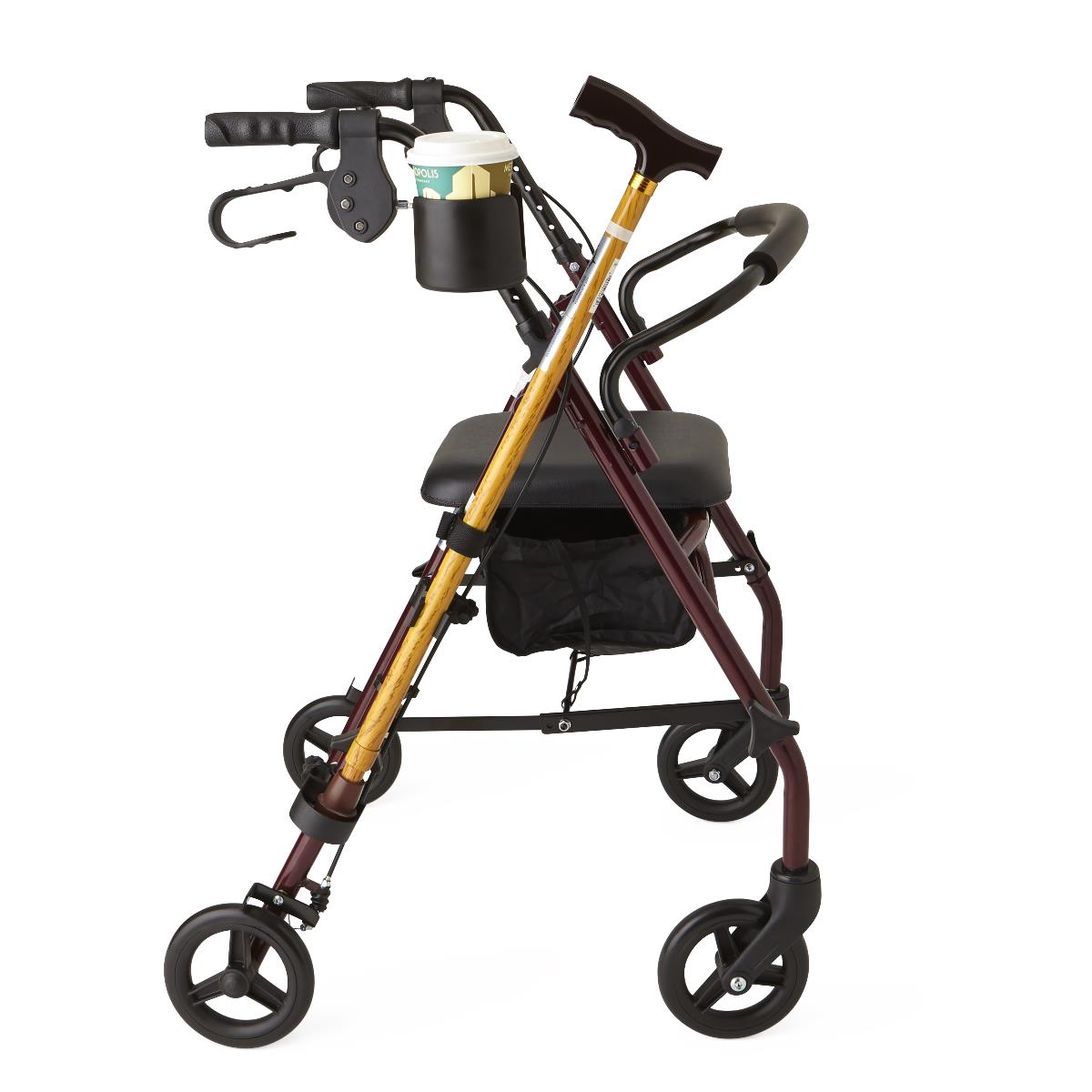 Cup and cane holder accessory mounted on a burgundy rollator, holding a coffee cup and gold cane with T-handle
