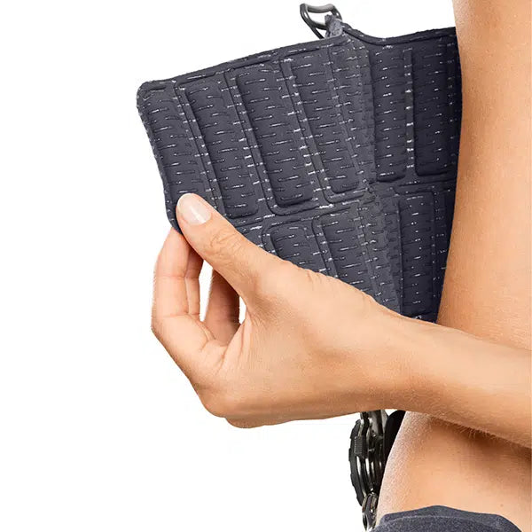 Epico ROM elbow brace shown being adjusted by hand, featuring a dark gray quilted padded panel with hook-and-loop closure