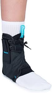 Ankle brace with figure 8 lace-up closure worn on left foot with white sock, shown from front angle