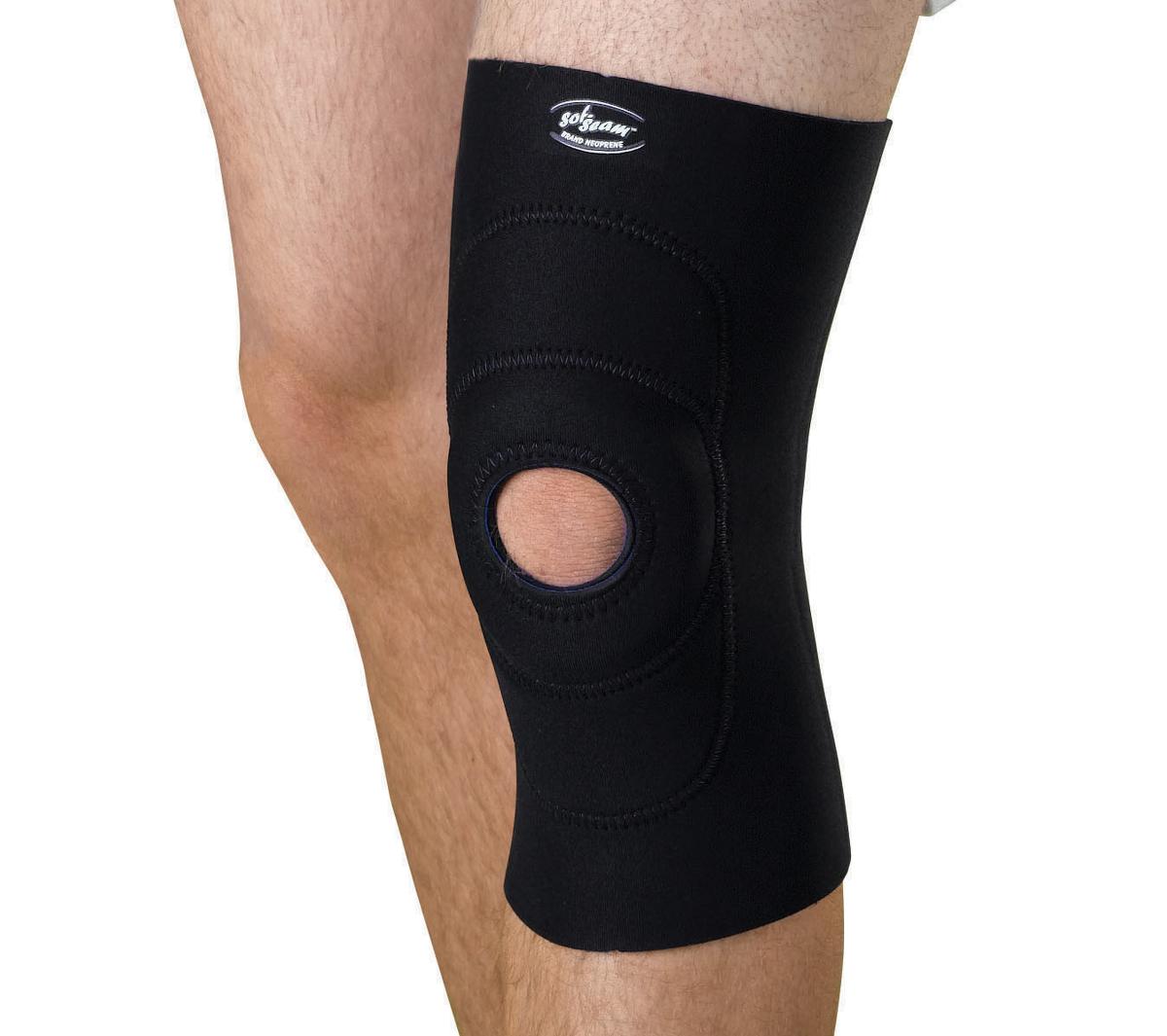 Knee support with open patella round buttress in black neoprene worn on a person's right leg