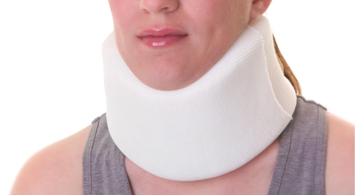 Soft cervical collar in white foam worn around a person's neck, shown from chin to chest against a white background