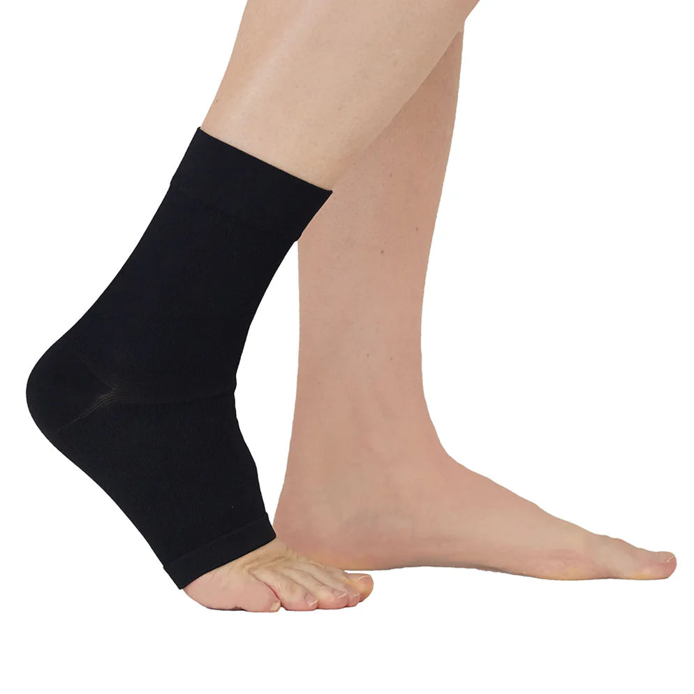 Ankle support sleeve in black seamless knit worn on a person's ankle, shown from the side against a white background