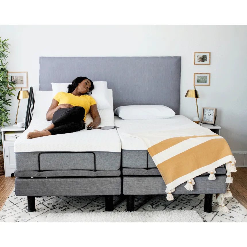 Adjustable electric bed with head section raised, shown with a woman reclining using a remote control in a bedroom setting