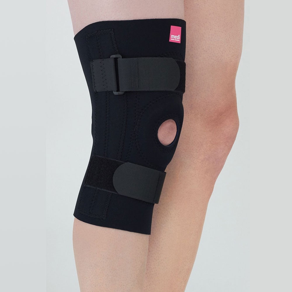 Knee stabilizer in black neoprene with open patella cutout and two adjustable straps, worn on right leg