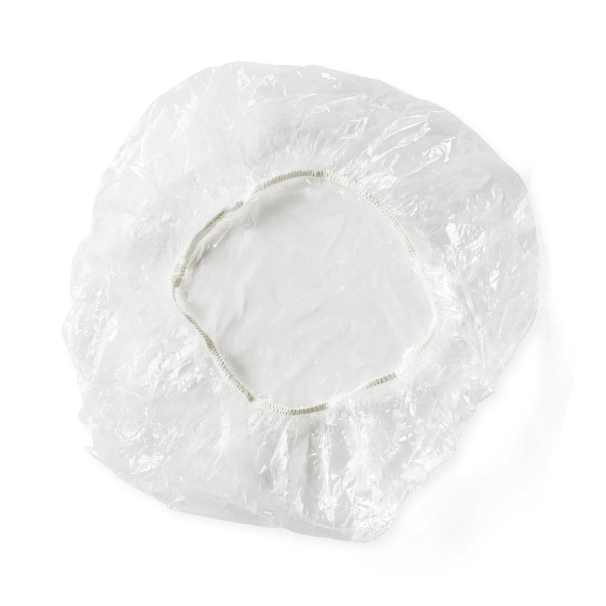 Disposable shower cap with clear plastic material and elastic band, viewed from above on white background