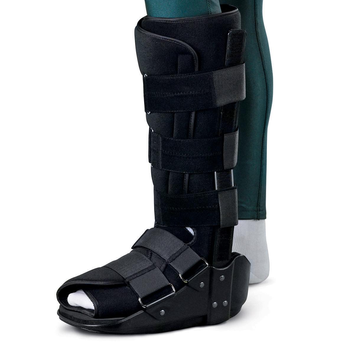 Short leg walker boot in black with adjustable hook-and-loop straps, worn on a foot and lower leg over a white sock