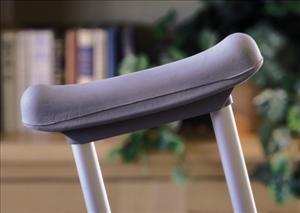 Crutch cushion cover in gray foam padding fitted over the underarm rest of aluminum crutches