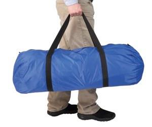 Carry bag for overlay mattress topper, blue cylindrical duffel style with black handles, held by person's hand