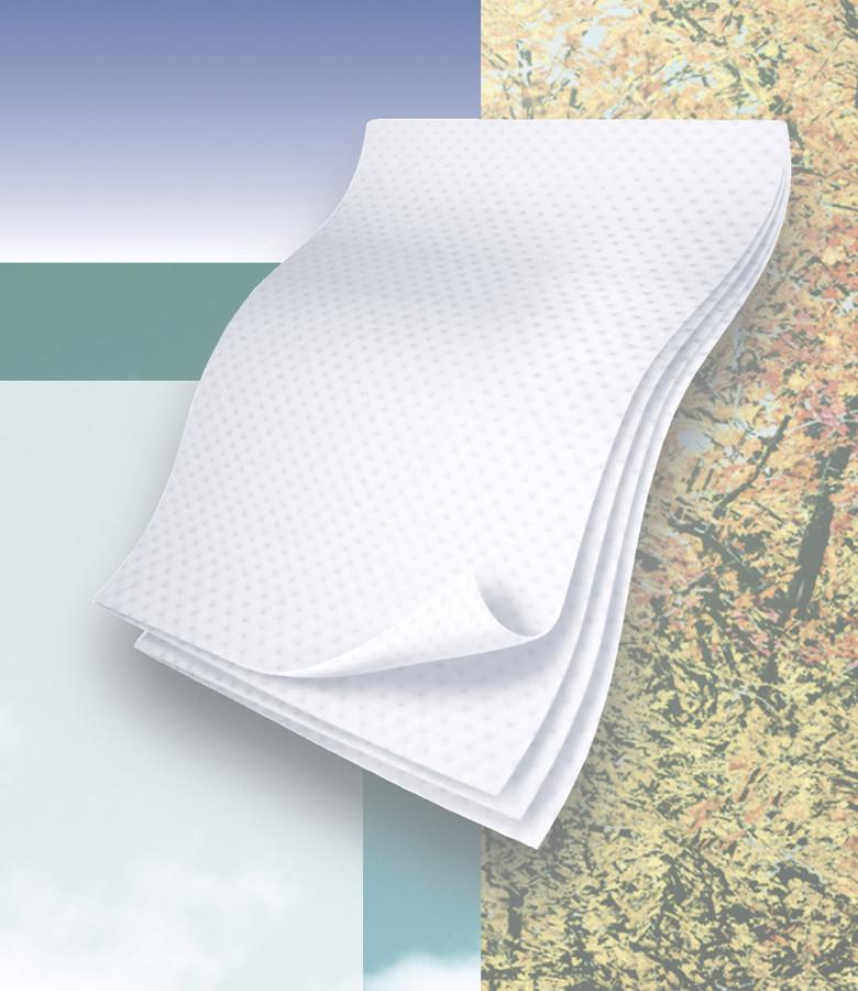 Flushable dry wipes stacked in a folded white embossed sheet against a multicolor nature-themed background