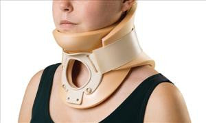 Rigid Philadelphia cervical collar with tracheotomy opening worn on a person's neck, beige foam and plastic construction