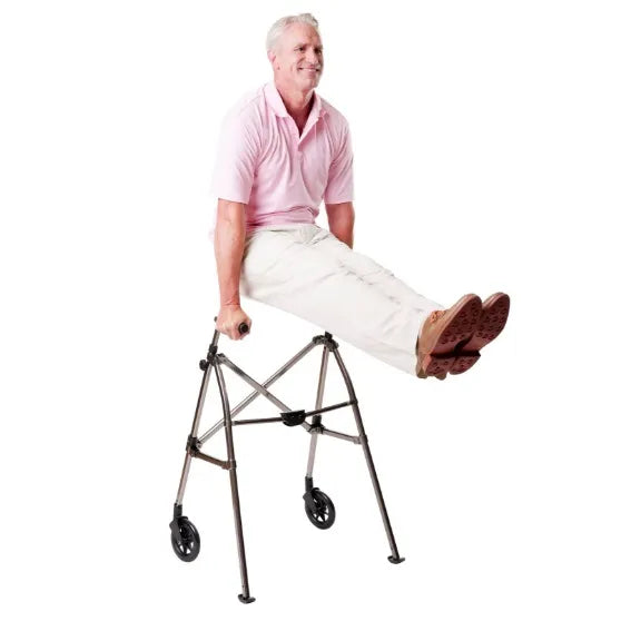Folding walker with front wheels supporting a seated older man in a pink polo shirt and white pants on a white background