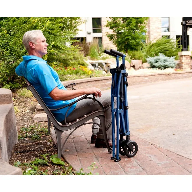 Folded blue walker with wheels standing upright beside an older man seated on an outdoor bench