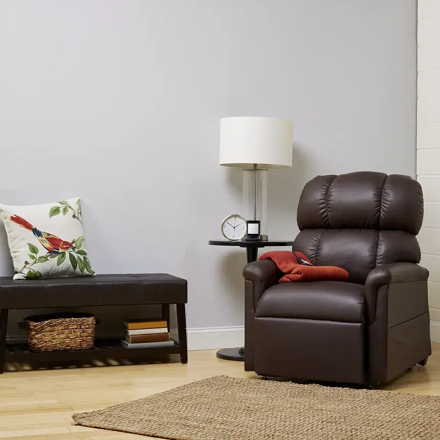 Lift chair recliner in dark brown upholstery shown upright in a furnished living room setting with remote on armrest