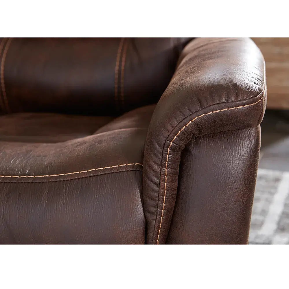 Lift chair armrest and seat detail showing brown faux leather upholstery with contrast stitching