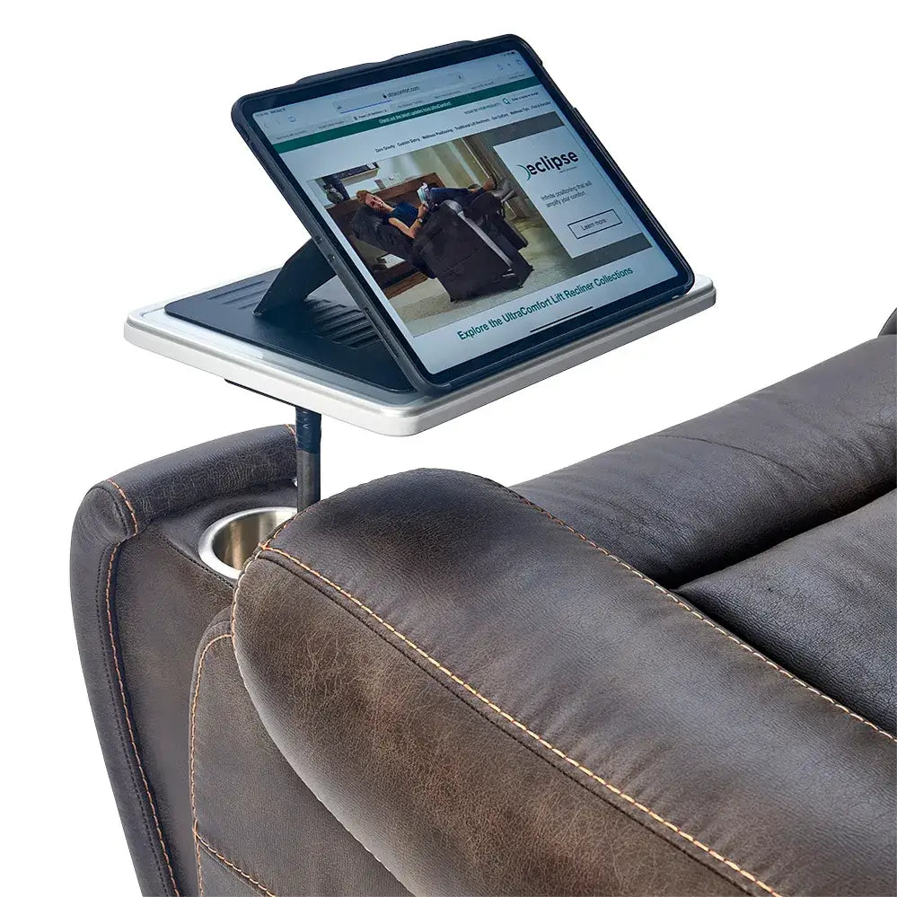 Lift chair swivel tray table with built-in tablet stand holding a tablet, mounted to the armrest of a brown upholstered lift