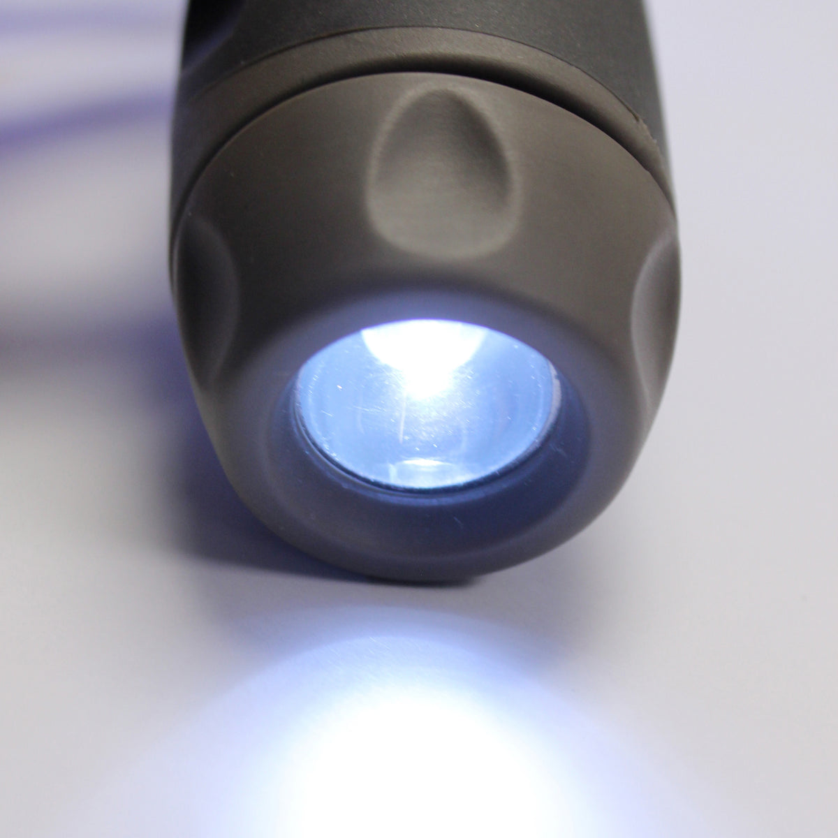 Car handle LED light close-up showing illuminated white beam on a dark gray rubberized grip end