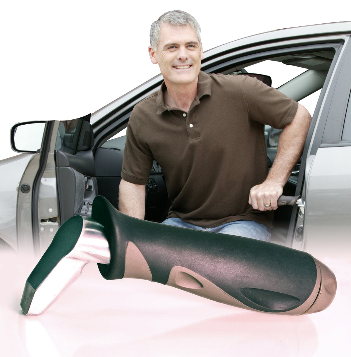 Car handle mobility aid shown in foreground with smiling man using it to exit a vehicle