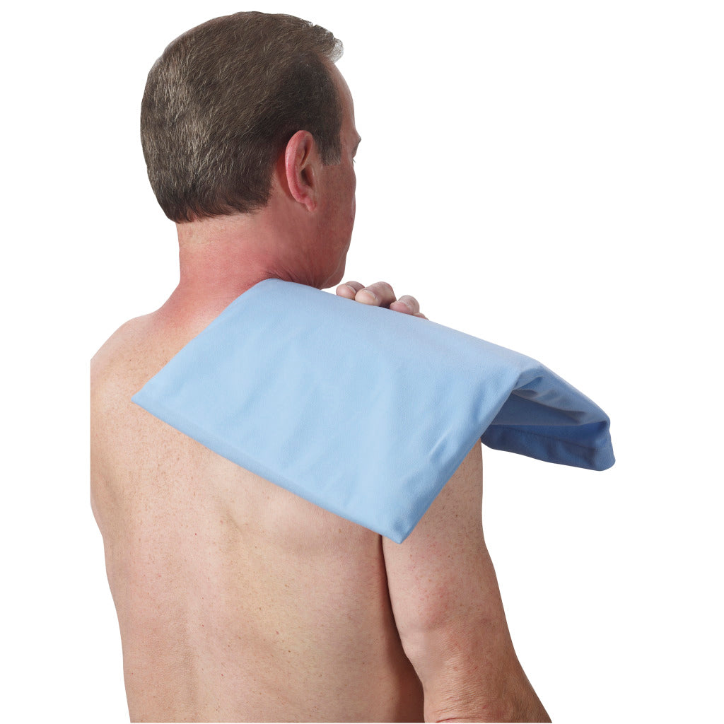 Moist-dry heating pad with light blue fabric cover applied to a man's upper back and shoulder area
