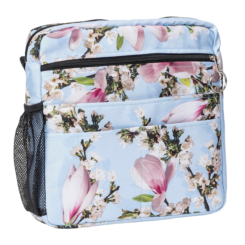 Walker tote bag with light blue floral print, zippered top, front pockets, and side mesh pocket
