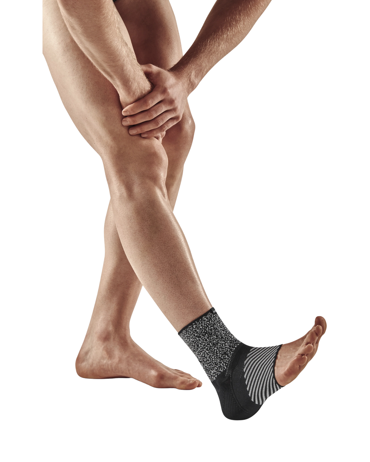 Ankle sleeve with black and gray knit fabric worn on a person's foot and ankle, shown against a white background