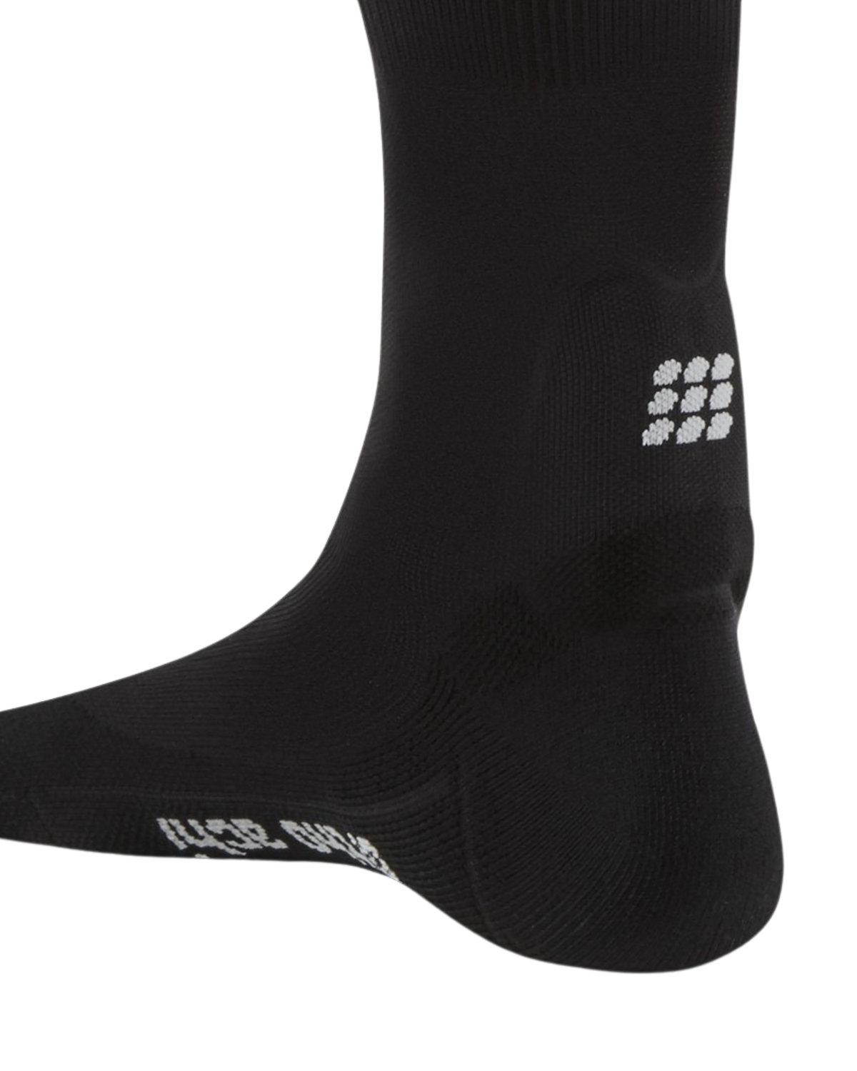 Achilles support compression sock in black with small white logo detail on ankle, shown on foot model against white