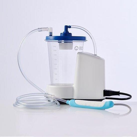 Urine collection system with motor unit, graduated canister, clear tubing, and light blue external catheter wand on white