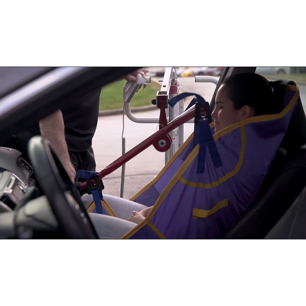 Car transfer mobile floor lift being used to assist a woman from a vehicle seat using a purple and yellow sling