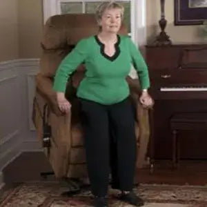 Lift chair in tan upholstery shown in raised position helping elderly woman stand in a home living room setting