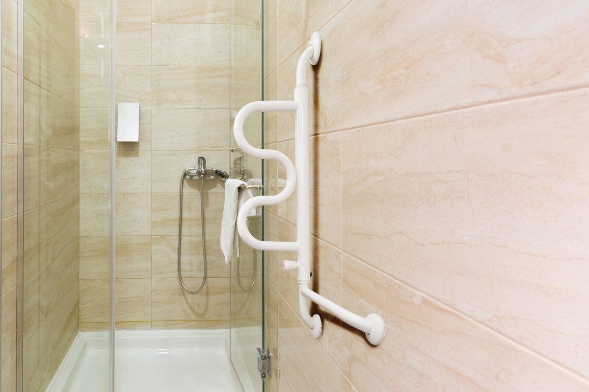 Curve grab bar wall-mounted safety handle in white installed on beige tile wall beside a glass shower enclosure